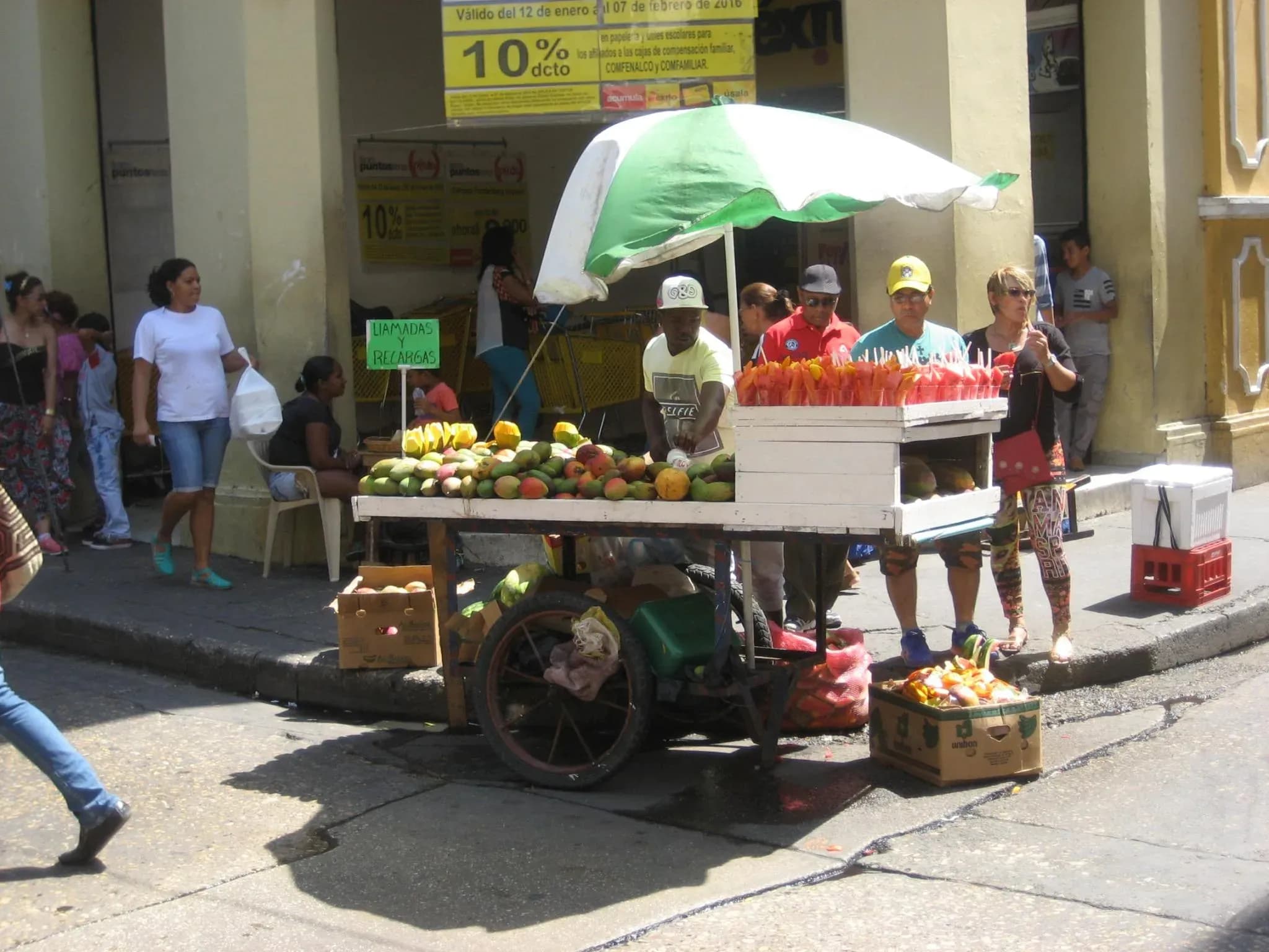 Vendedor ambulante de frutas en Cartagena con frutas tropicales coloridas exhibidas en un carrito