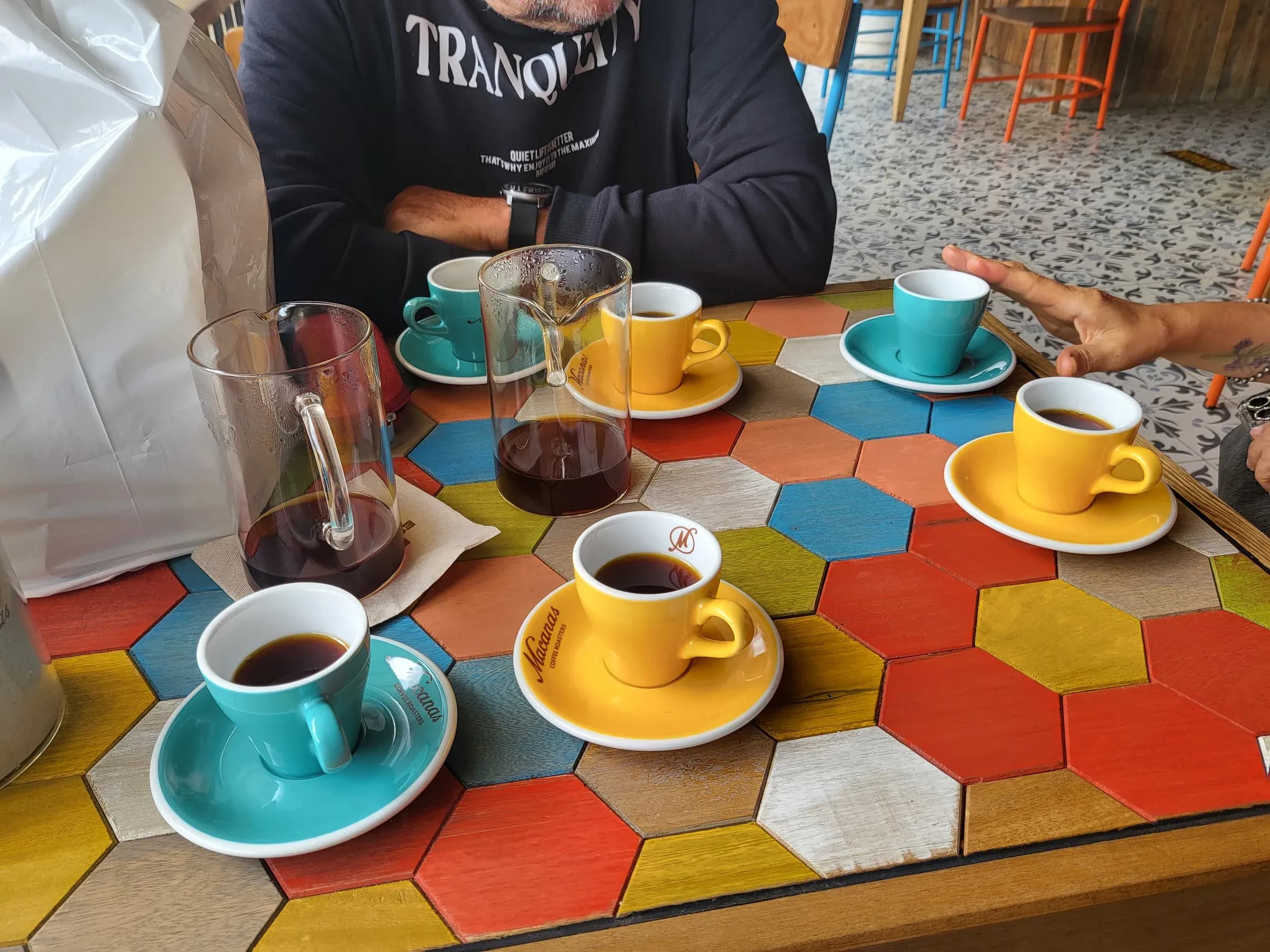 Evento de cata de cafe con tazas de cupping y participantes en Jardin, Colombia