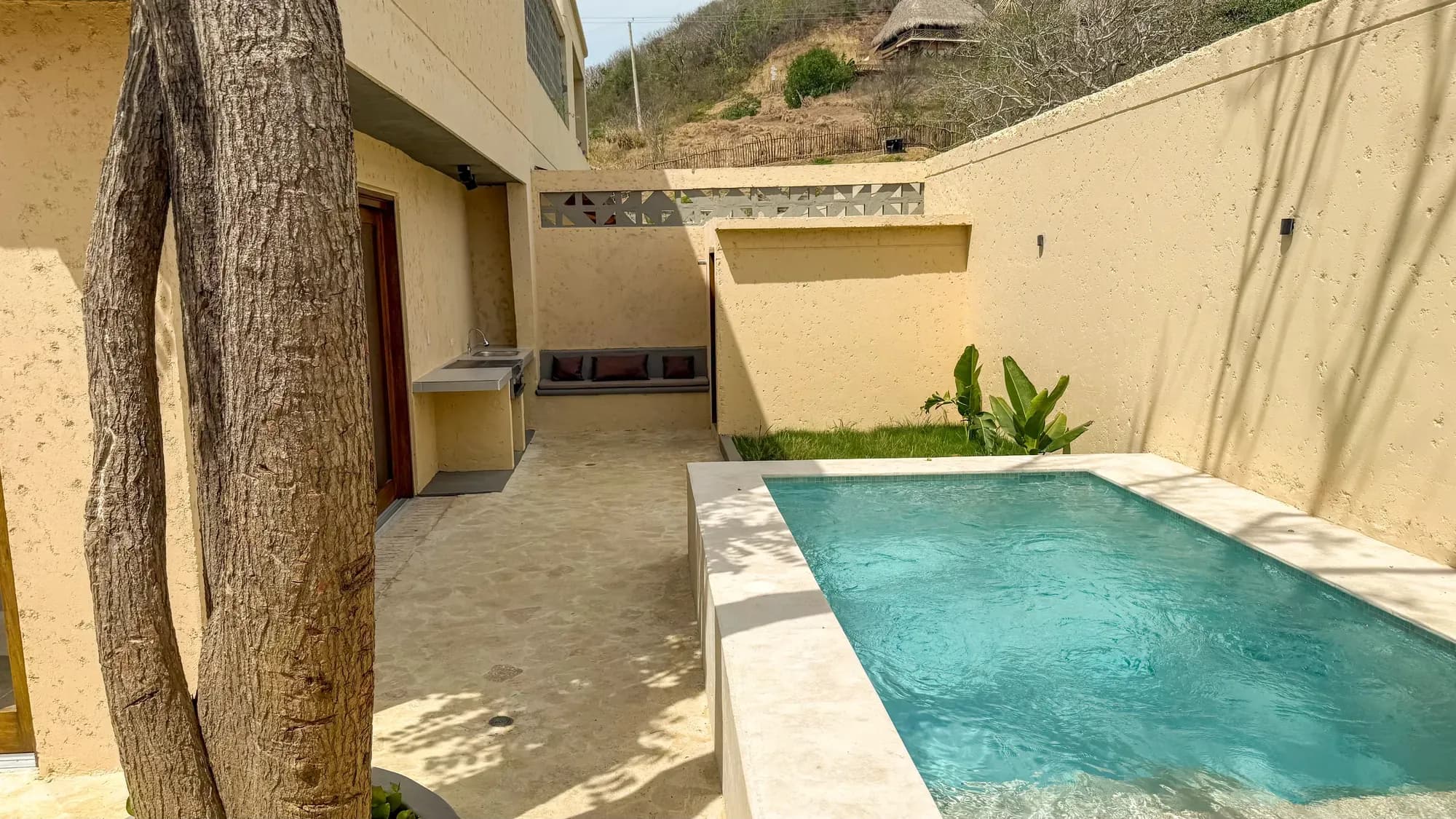 Piscina de inmersion con muros de piedra y vista a la colina sobre el parapeto