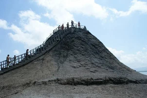 Visitantes subiendo escaleras de madera a la cima del cono del Volcan del Totumo