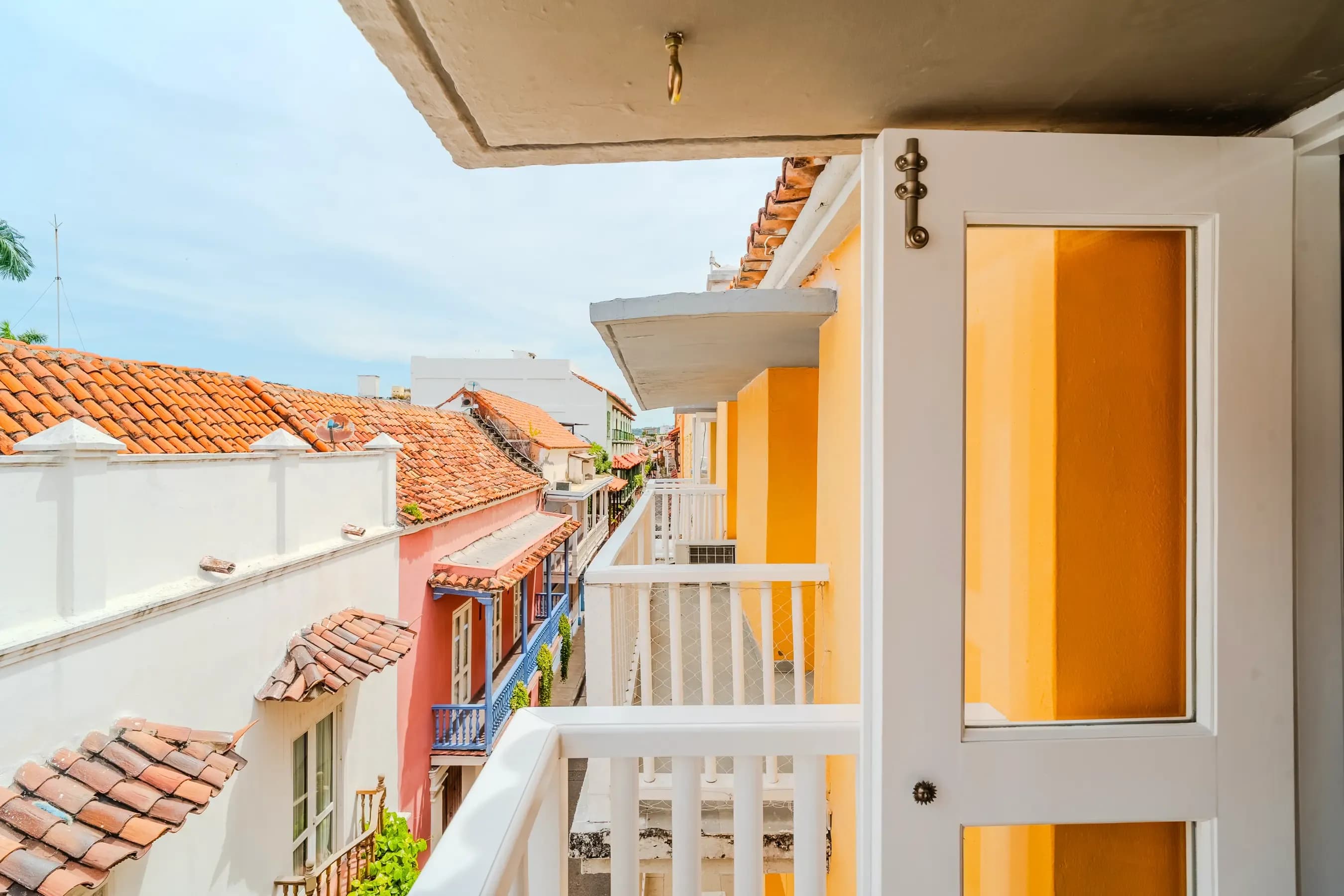 Vista del balcon sobre techos coloniales coloridos con edificios amarillos y tejas de barro en Cartagena